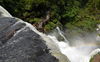 Kleine Menschen unterhalb eines der Wasserfälle in Iguazu
